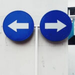 緊急避難における二者択一の選択を象徴する道路標識のイメージ