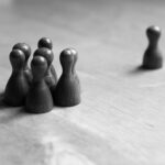 共犯関係から一人が離脱する状況をチェスの駒で表現したイメージ