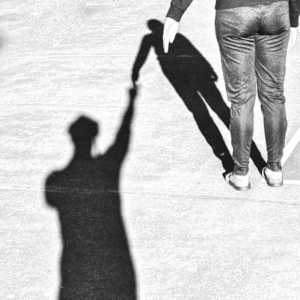 右上に立つ人物の影を、左下の別の影が手を差し伸べて支えているモノクロのシルエット画像