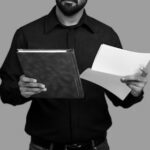 2つの文書を持ち比較する様子（供述の矛盾・自己矛盾供述のイメージ）